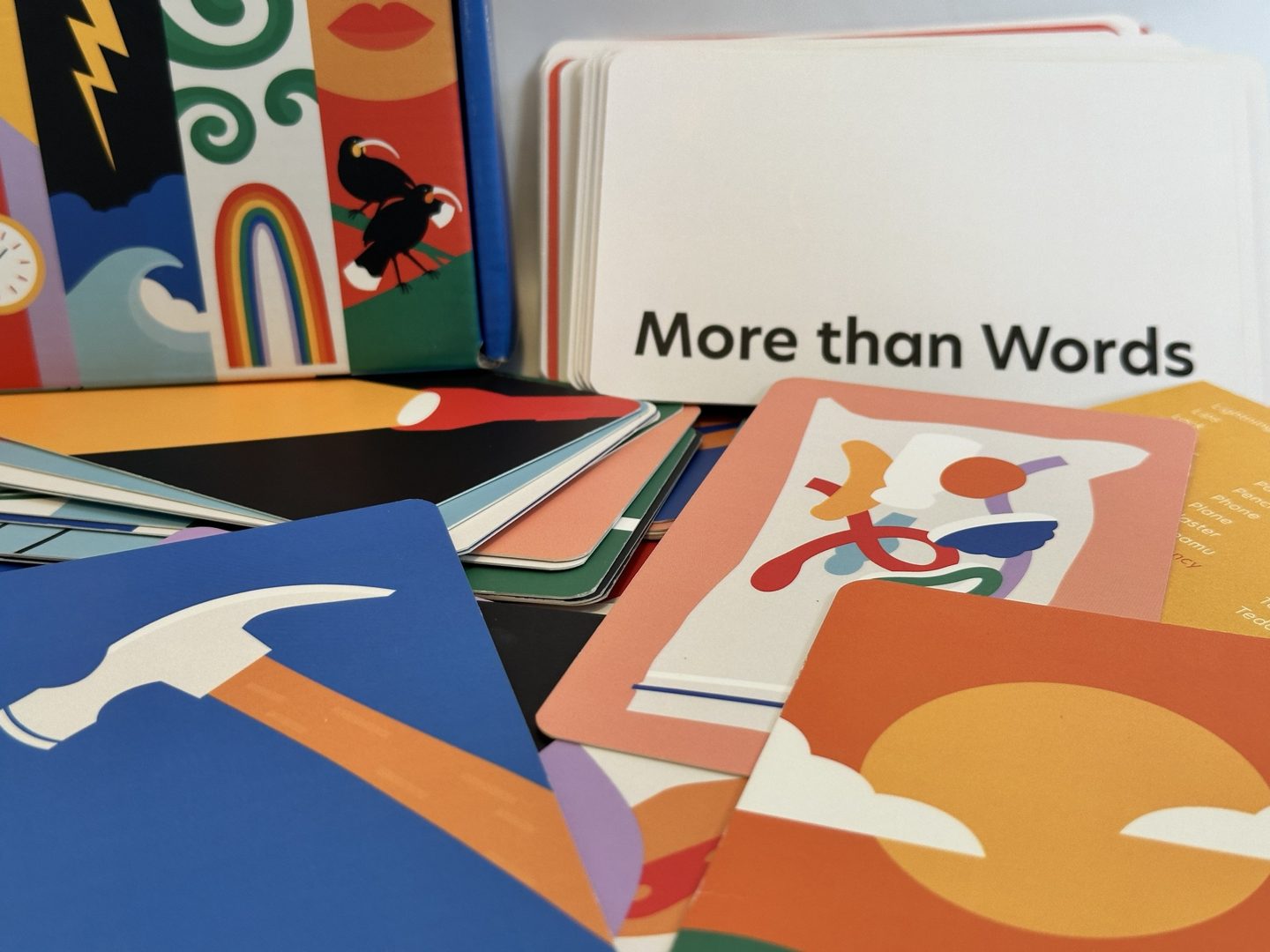 The More than Words box and title card with a spread of illustrated image cards, among them a hammer and a sun behind clouds.